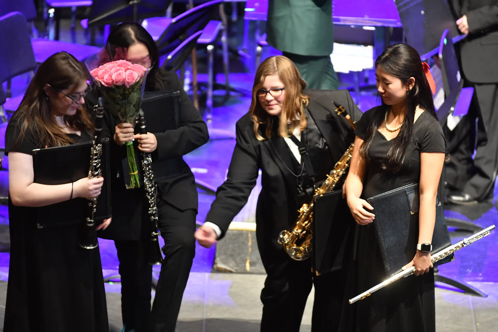 Four South Lyon student woodwind performers sharing a moment on stage