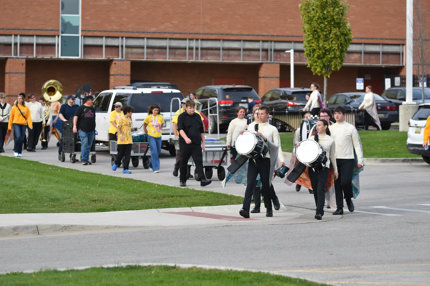 South Lyon marching students arriving at a performance with their instruments in 2026
